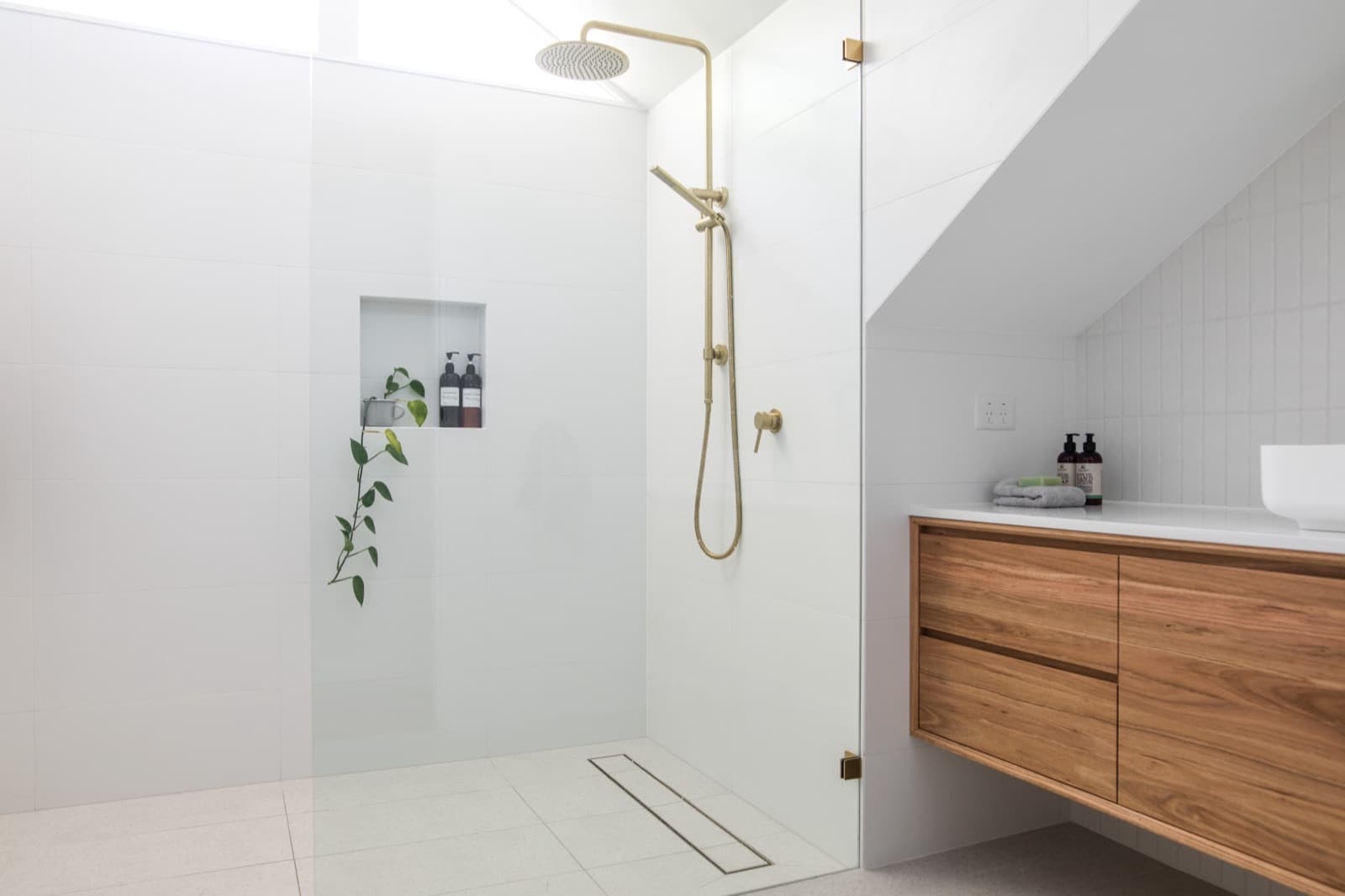 Bathroom inspiration with a glass shower, wood vanity and brass fixtures