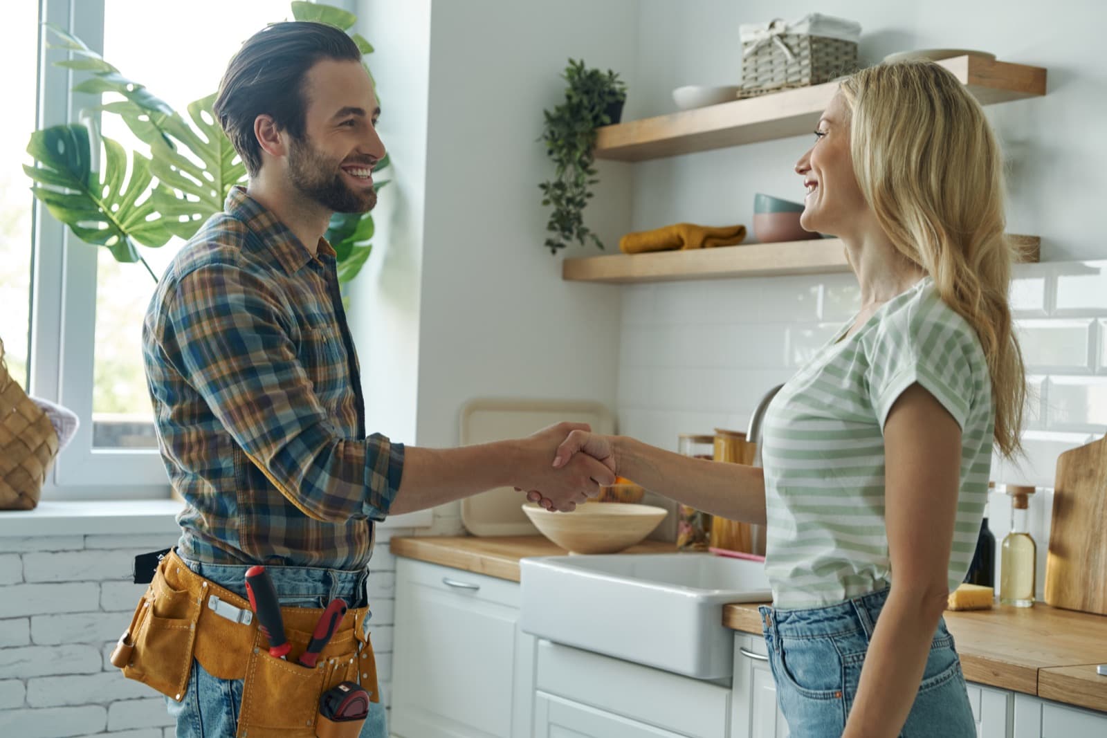 Plumber shaking hands with a homeowner — Bedford is our headquarters city